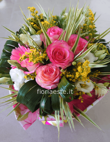 Bouquet assortito di rose rosa, gerbere, lisianthus e fiori e verdi di complemento.